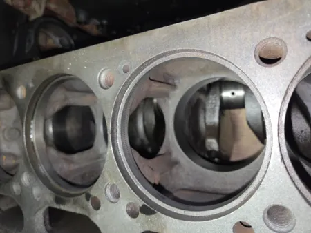 Zwei Zylinderbohrungen eines Multicar Dieselmotors mit Blick auf die darunterliegende Kurbelwelle