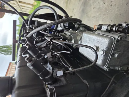 Nahaufnahme der Düsenhalter und Hochdruck-Einspritzleitungen auf dem Zylinderkopf eines Multicar Dieselmotors