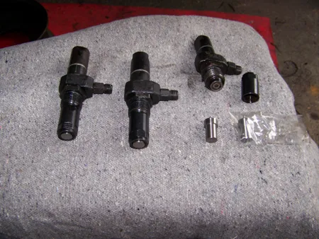 Zerlegte Düsenhalter und Bauteile der Einspritzdüsen eines Multicar Dieselmotors